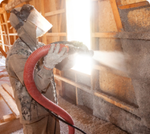 Cellulose installer, installing cellulose insulation inside a home's walls.