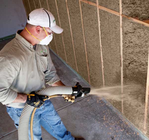 Insulation installer, installing Greenfiber insulation in home.