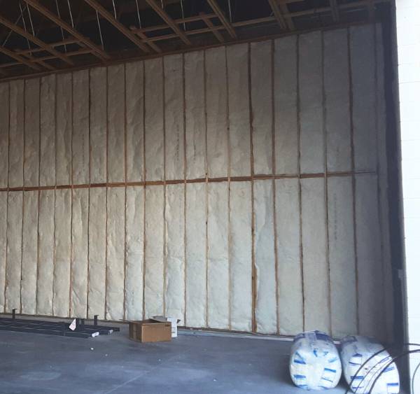 Fiberglass insulation installation in commercial building.