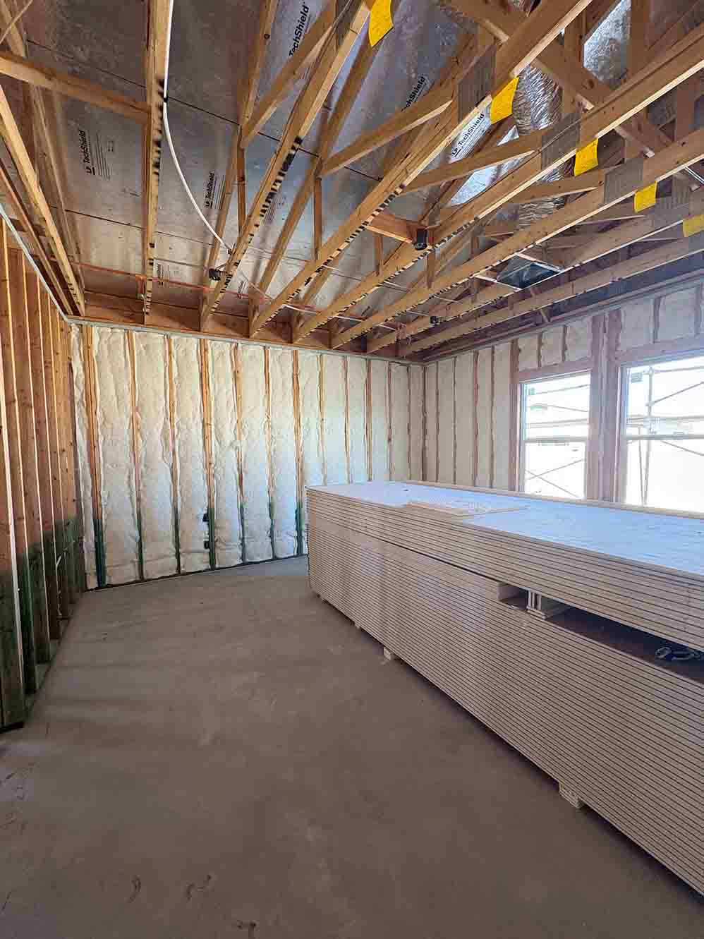 Unfaced fiberglass batt insulation installed in the exterior walls of a corner room in a new-construction.